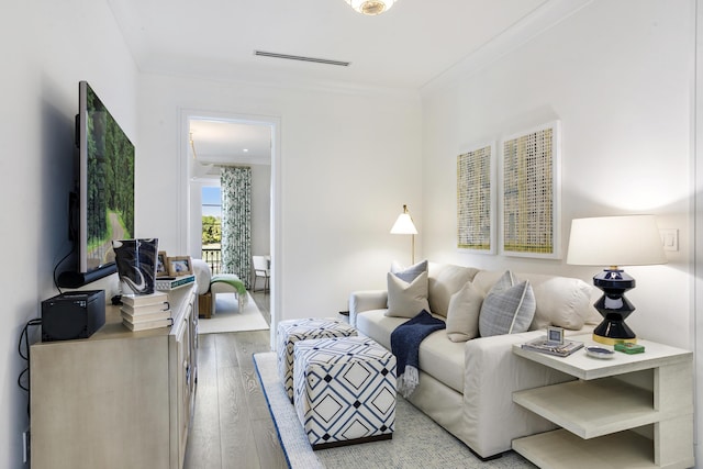 living room with light hardwood / wood-style floors and crown molding