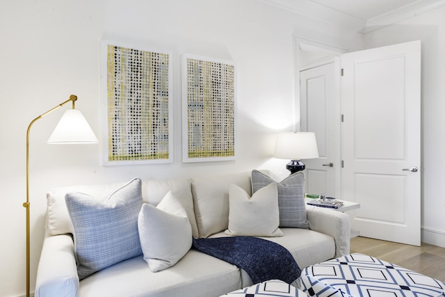 living area featuring crown molding and light hardwood / wood-style floors