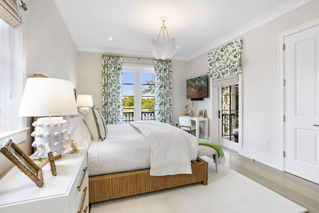 bedroom featuring access to exterior, light hardwood / wood-style floors, multiple windows, and ornamental molding