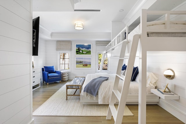 bedroom with hardwood / wood-style flooring and crown molding