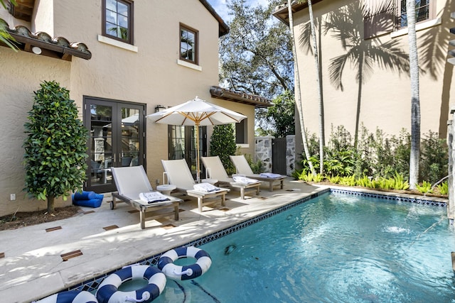 view of swimming pool featuring a patio area and french doors