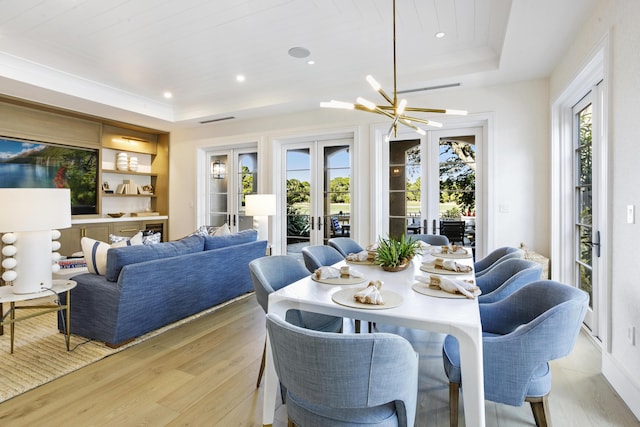 dining space featuring french doors, wooden ceiling, light hardwood / wood-style flooring, a notable chandelier, and a tray ceiling