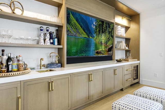 bar with light hardwood / wood-style flooring and sink