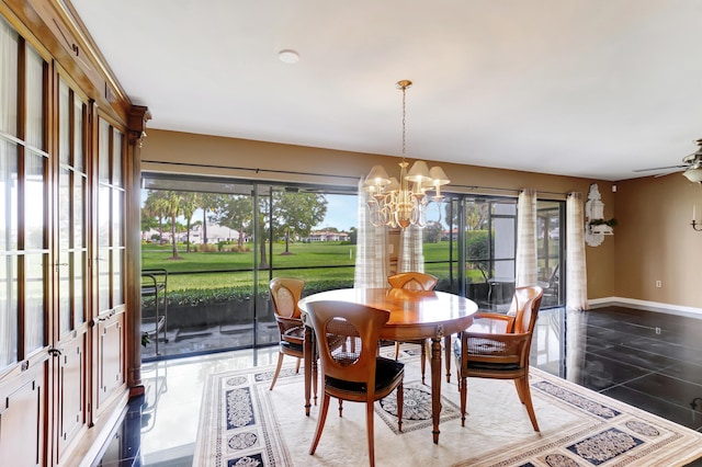 tiled dining room featuring a healthy amount of sunlight and ceiling fan with notable chandelier