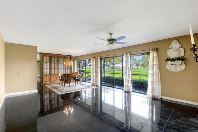 interior space featuring ceiling fan with notable chandelier and dark tile patterned floors