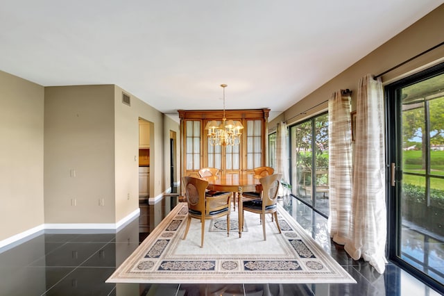 dining space featuring dark tile patterned floors and a notable chandelier