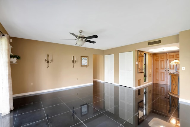 tiled empty room featuring ceiling fan