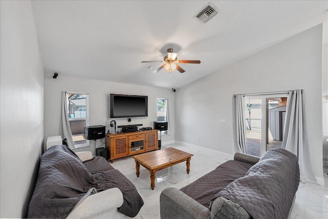 living room featuring ceiling fan, a healthy amount of sunlight, and lofted ceiling