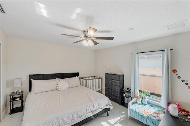 bedroom with a textured ceiling and ceiling fan