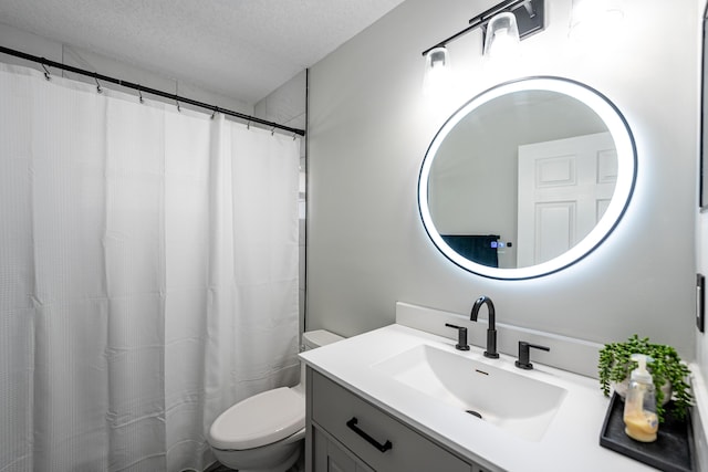 bathroom featuring vanity, a textured ceiling, and toilet