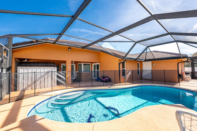 view of swimming pool featuring glass enclosure and a patio area