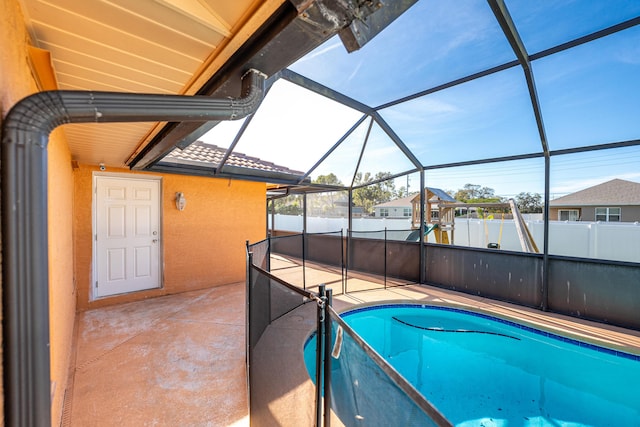 view of swimming pool featuring a patio and glass enclosure