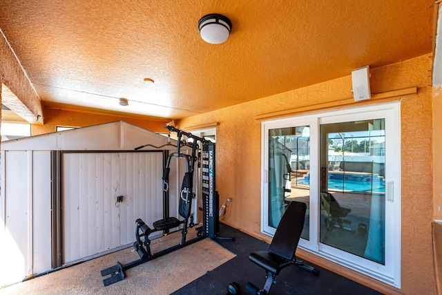 workout room with a textured ceiling and lofted ceiling