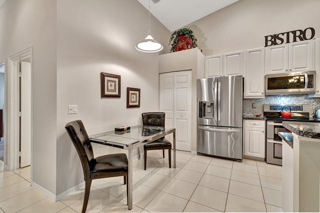 kitchen featuring appliances with stainless steel finishes, backsplash, white cabinets, and high vaulted ceiling