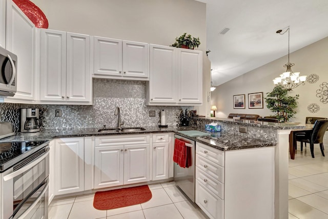 kitchen with sink, light tile patterned floors, appliances with stainless steel finishes, kitchen peninsula, and white cabinets