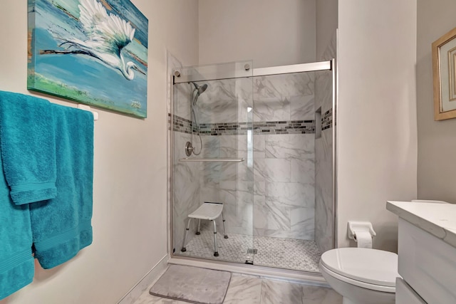 bathroom featuring vanity, a shower with shower door, and toilet