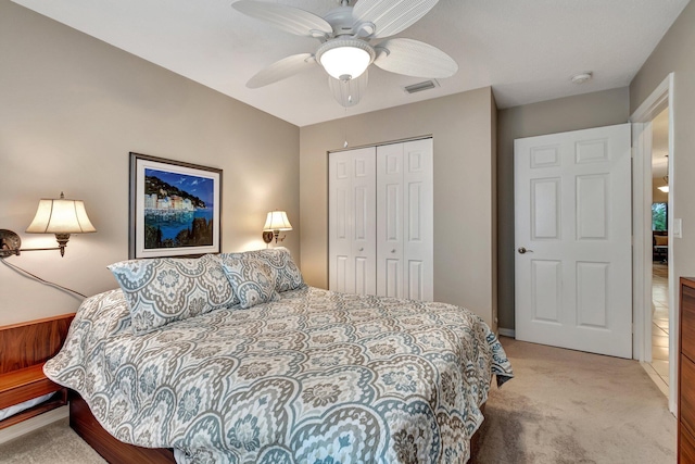 carpeted bedroom with ceiling fan and a closet