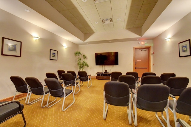 home theater with light colored carpet and a tray ceiling