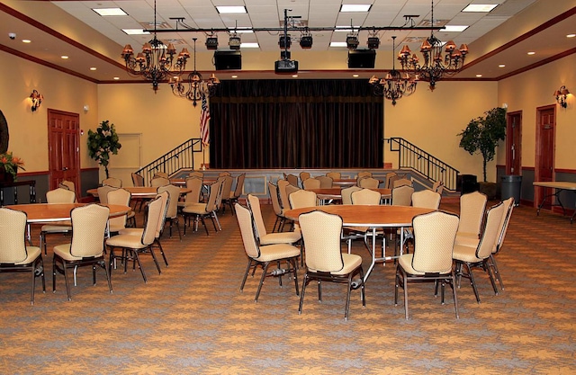 carpeted dining space with a towering ceiling, ornamental molding, and a notable chandelier