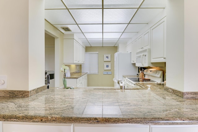 kitchen featuring white cabinets, white appliances, light stone countertops, and a paneled ceiling