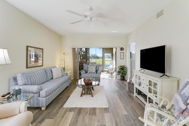 living room with ceiling fan and dark wood-type flooring