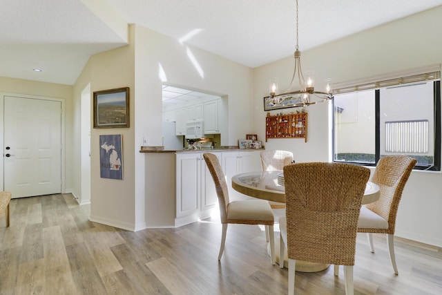 dining space featuring light hardwood / wood-style floors and a notable chandelier