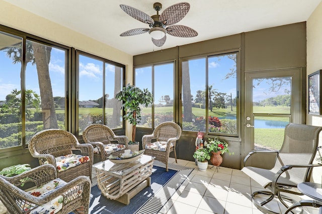 sunroom featuring a water view and ceiling fan