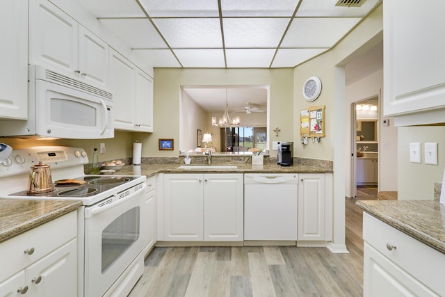 kitchen featuring white appliances, white cabinetry, and sink