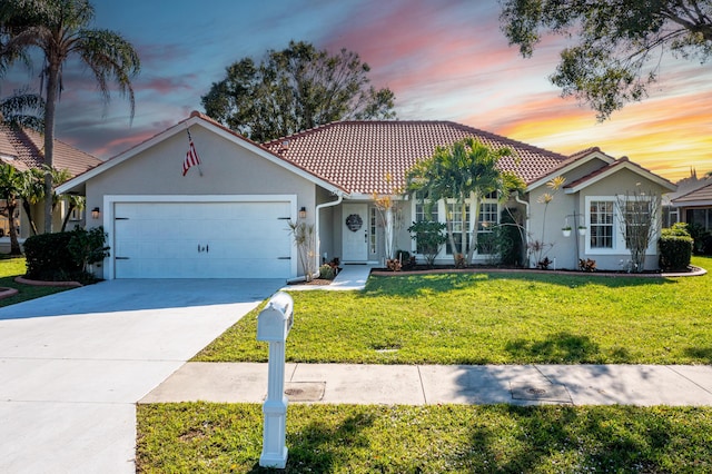 view of front of home with a garage and a yard