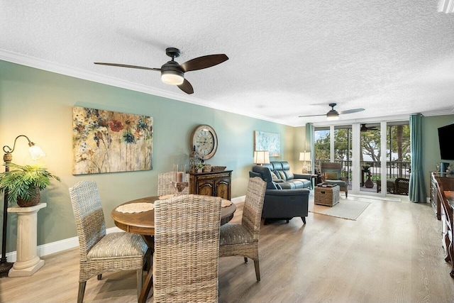 dining space with a textured ceiling, light hardwood / wood-style flooring, ceiling fan, and ornamental molding