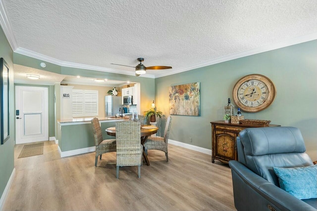 dining space with a textured ceiling, light hardwood / wood-style floors, and ceiling fan