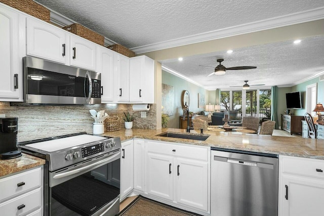 kitchen with kitchen peninsula, stainless steel appliances, and white cabinets