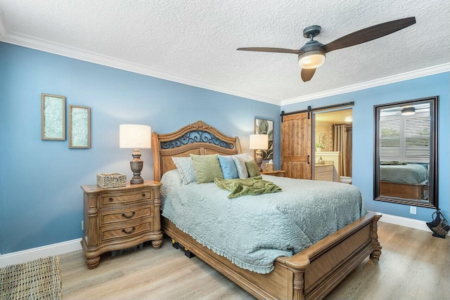 bedroom featuring a barn door, ceiling fan, light hardwood / wood-style flooring, and ornamental molding