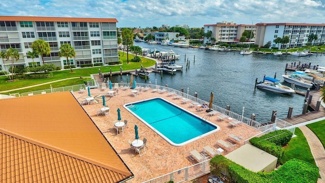 view of swimming pool with a water view and a patio area