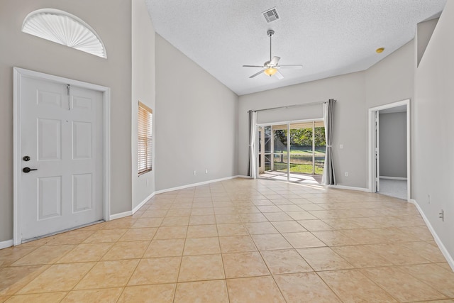 tiled entrance foyer with ceiling fan, plenty of natural light, high vaulted ceiling, and a textured ceiling