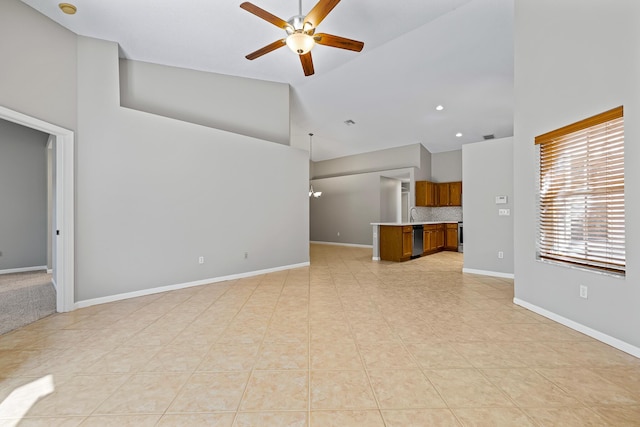 unfurnished living room with ceiling fan, sink, and high vaulted ceiling