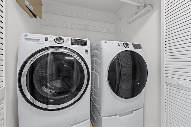 clothes washing area with washing machine and dryer