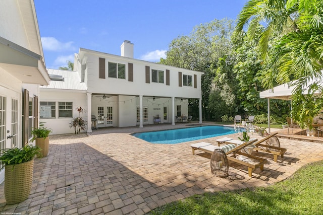 view of swimming pool featuring french doors, ceiling fan, and a patio area