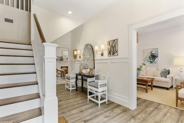 staircase with hardwood / wood-style floors and a fireplace