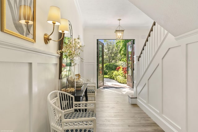 doorway featuring crown molding and light hardwood / wood-style flooring