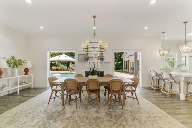 dining room featuring dark hardwood / wood-style floors, a fireplace, and an inviting chandelier