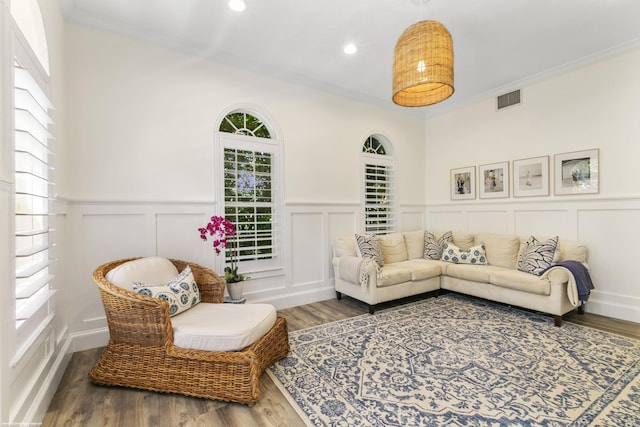 living room featuring wood-type flooring and ornamental molding