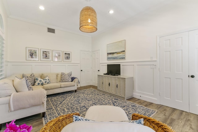 living room with hardwood / wood-style floors and ornamental molding