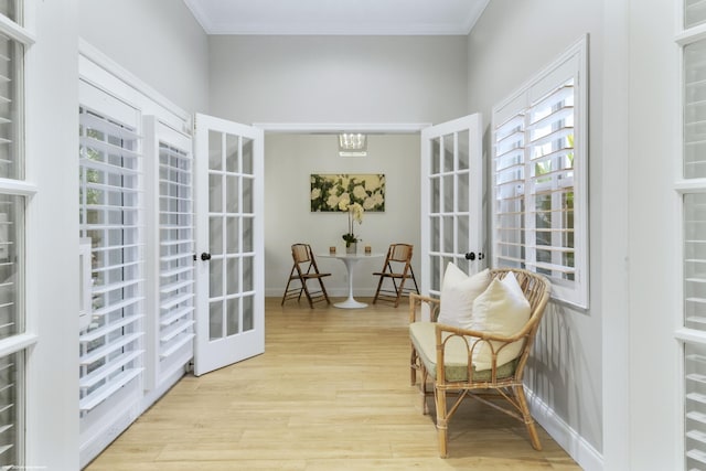 living area featuring french doors, light hardwood / wood-style flooring, and ornamental molding