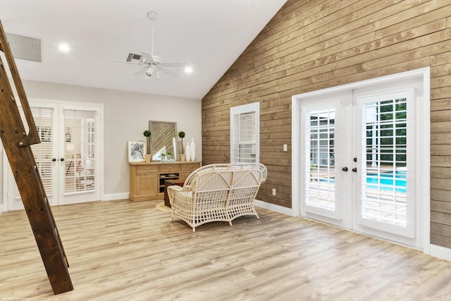 sitting room with ceiling fan, french doors, light hardwood / wood-style floors, and vaulted ceiling