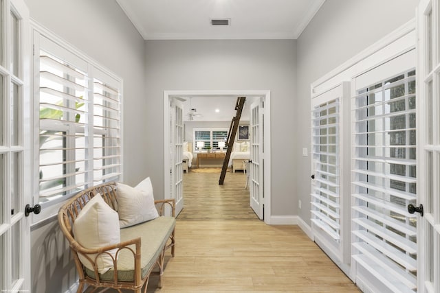 interior space with crown molding, light hardwood / wood-style flooring, and french doors