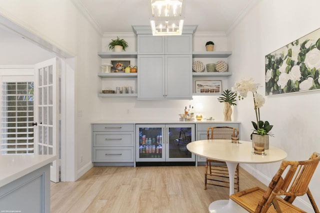 bar featuring gray cabinets, beverage cooler, and crown molding