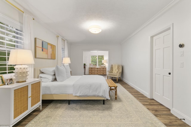 bedroom with a textured ceiling, crown molding, and dark hardwood / wood-style floors