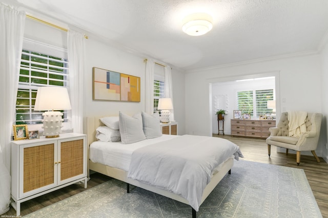 bedroom with dark hardwood / wood-style floors, crown molding, and a textured ceiling