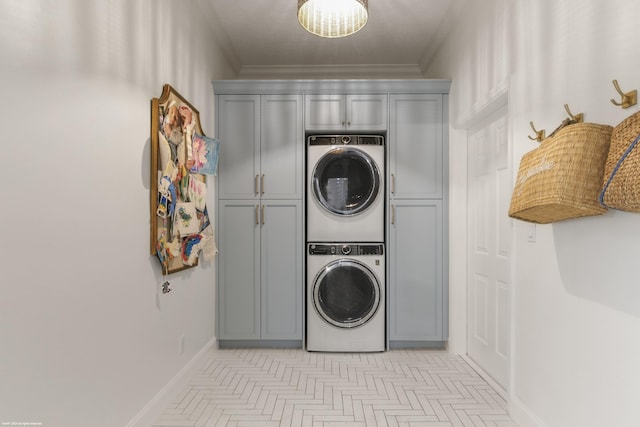 laundry area with cabinets, ornamental molding, and stacked washer / dryer